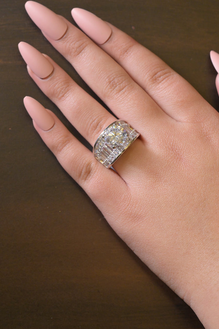 Hand wearing a diamond ring on a dark background